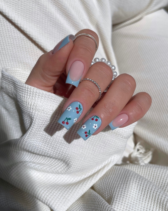 matte blue square nails with cherry and floral art and French tips on nude base 