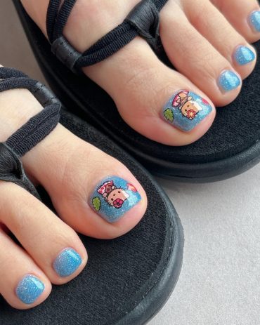 Blue glitter toe nails with Hello Kitty and bear stickers on big toes, beach theme style.