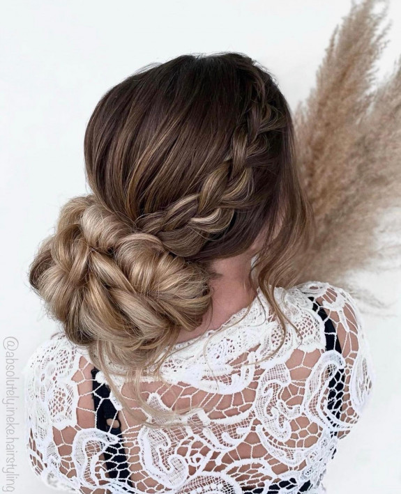 Side braid bridal bun with voluminous twisted weave.