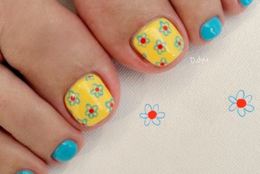 Bright yellow and aqua blue toe nails with daisy floral prints, a cheerful and playful summer pedicure