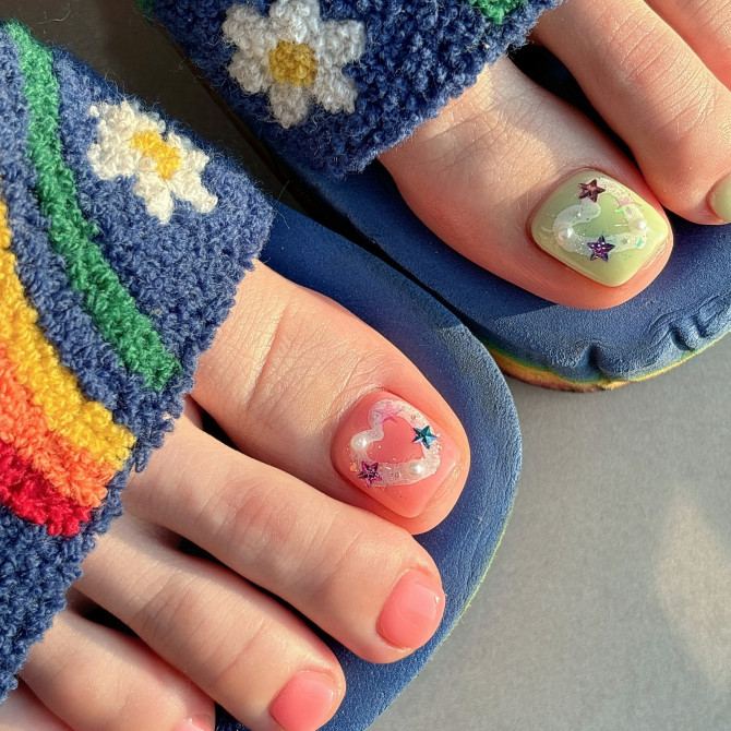 Toe nails in pastel pink and mint green with 3D heart charms and colorful star decorations on short, neat nails