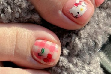 Toenail art featuring Hello Kitty face and cherry design over red gingham checks on big toes, with glossy nude finish on smaller toes