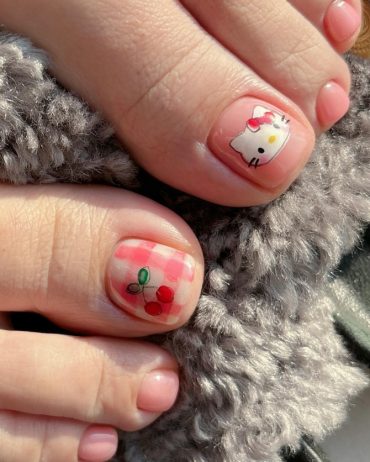 Toenail art featuring Hello Kitty face and cherry design over red gingham checks on big toes, with glossy nude finish on smaller toes