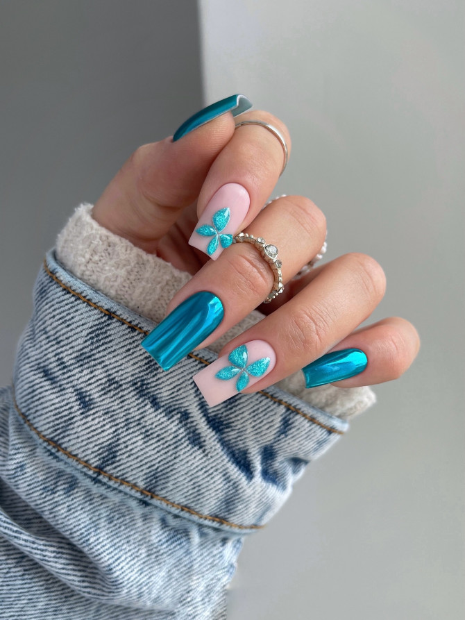 long coffin chrome teal nails with 3D turquoise flower accent on nude base