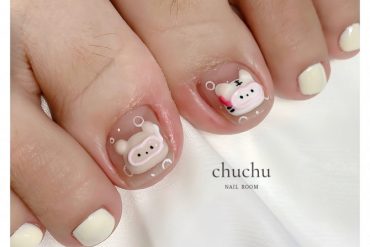 Toe nails with nude base and 3D piggy and bunny designs, paired with off-white polish on surrounding toes