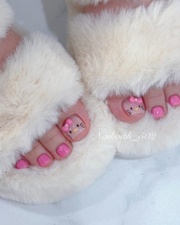 Cute Hello Kitty pedicure with pink polish on all toes and hand-painted character faces with pink bows on big toes.