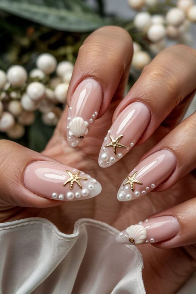 Nude almond nails with gold starfish and pearl shell accents for summer