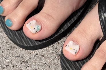 Hello Kitty toe nail art with teal polish and character face on big toe