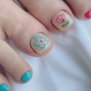 Glitter nude toenails with pink bear and aqua flower design, paired with vibrant turquoise and pink accents