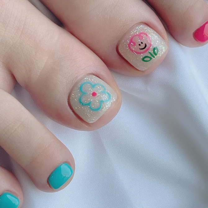 Glitter nude toenails with pink bear and aqua flower design, paired with vibrant turquoise and pink accents