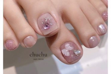 Soft pink toe nails with shimmer finish, crystal cherry and 3D bow embellishments in neat square shape