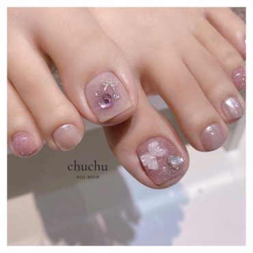 Soft pink toe nails with shimmer finish, crystal cherry and 3D bow embellishments in neat square shape