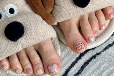 Toe nails with heart design, red love message, and pastel polka dots on a nude-pink base