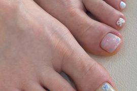 Toe nails in pastel shades with 3D blue bows and glitter jelly polish on short square shape