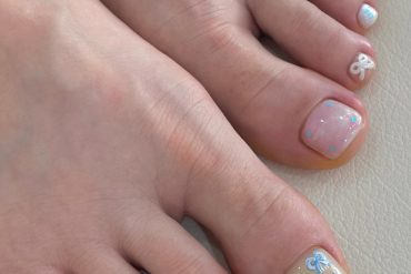 Toe nails in pastel shades with 3D blue bows and glitter jelly polish on short square shape