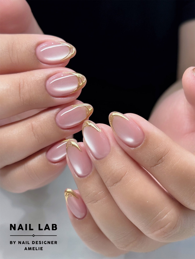shimmery pink almond nails with gold marble swirl tips