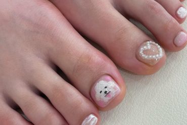 Toe nails with hand-painted white puppy, 3D pearl heart, and soft pink and white shimmer polish in short square shape