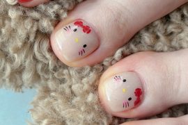 Square toe nails with Hello Kitty design on nude base and surrounding toes painted in glossy red
