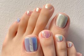 Aurora-inspired pastel toenails in iridescent hues of lavender, mint, pink, and cream, with a seashell-like glossy finish.