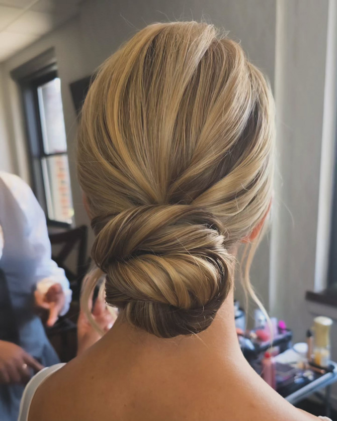  Low chignon bridal hairstyle with honey-blonde highlights.