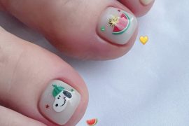 Toe nails with white polish featuring Snoopy and watermelon cartoon art on big toes in a cute summer style