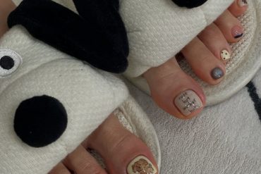 Toe nails with teddy bear art, handwritten-style text, polka dots and neutral pastel polish in short square shape