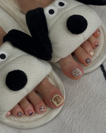Toe nails with teddy bear art, handwritten-style text, polka dots and neutral pastel polish in short square shape