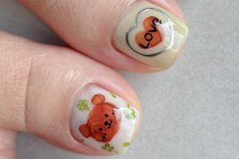 Toe nails with hand-painted teddy bear, green clovers, and double heart with “Love” text on a nude base