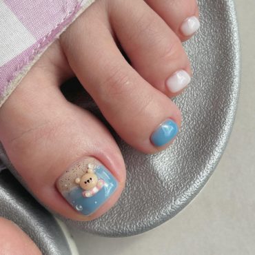 Toe nails with teddy bear art on big toe, soft blue and white polish on short square nails in vacation theme