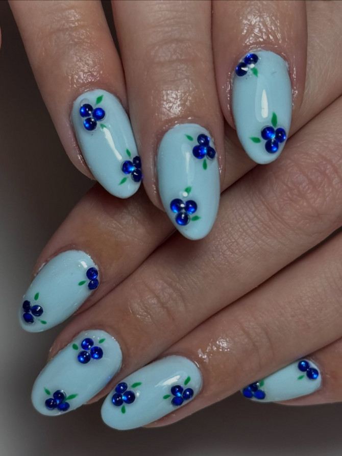 blueberry nail designs with rhinestone berries on sky-blue base for summer sparkle