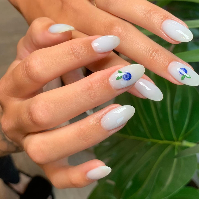 minimalist blueberry nail designs with milky-white base and single berry accents