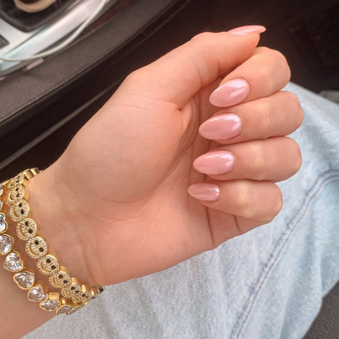 Short almond-shaped bridal nails in a glossy nude-pink finish—perfect for brides seeking effortless elegance and timeless simplicity.