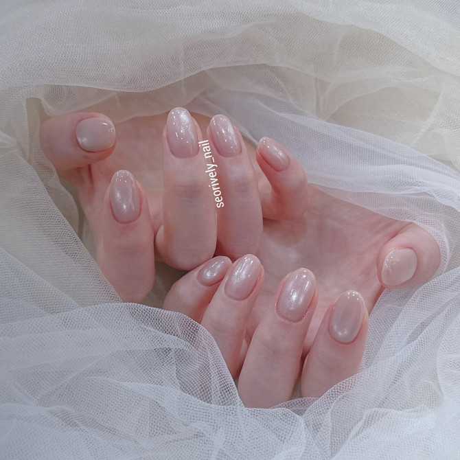Short oval nude nails with a soft pink glaze and subtle shimmer—perfect for a minimalist bride who loves elegant simplicity. Classic French bridal nails with subtle sparkle"