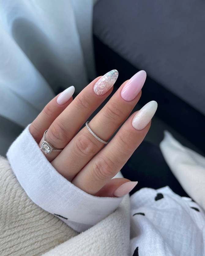 Elegant almond-shaped bridal nails featuring a mix of soft pink, pearlescent white, and a sparkling iridescent accent nail for a dreamy wedding manicure.