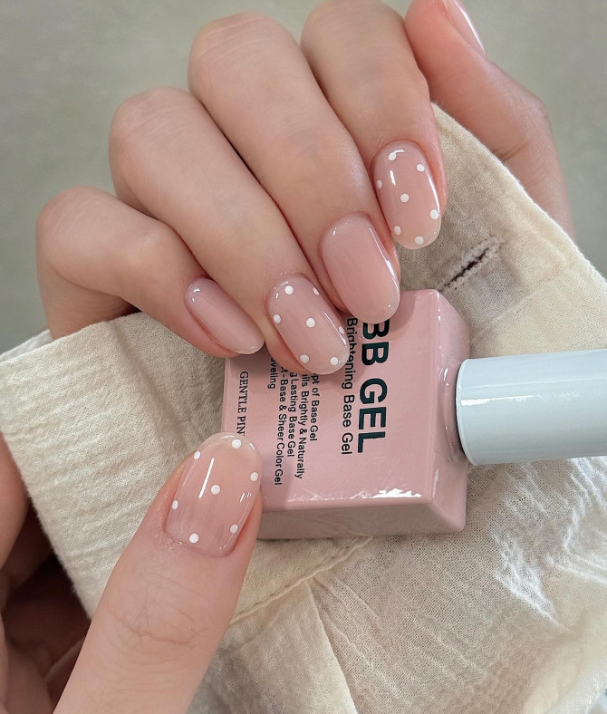 Mint green French tips with mini white bows on a nude base.