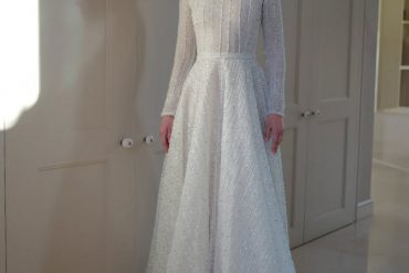 Elegant long-sleeve high-neck bridal gown with shimmering details by Zehavi Pick Bridal.
