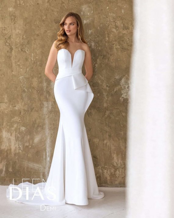Bride in strapless mermaid wedding gown with sculptural side peplum and V neckline – Leen Dias