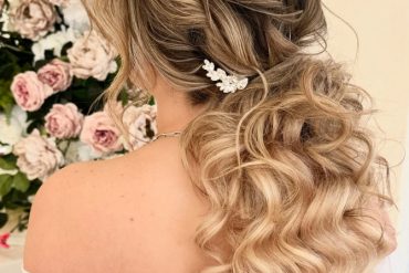 Romantic bridal ponytail hairstyle with soft curls and twisted details by @shannonsarabridalhair.