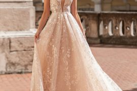 Bride wearing a deep V-neck A-line wedding dress with cap sleeves and floral lace by Leen Dias