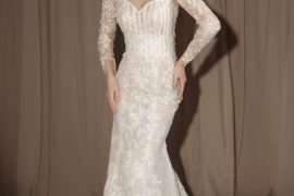 Bride in a long sleeve lace wedding dress with illusion neckline and fitted silhouette – Photo via IG @oddypranatha