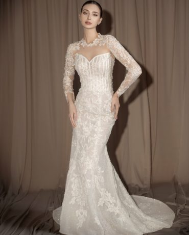 Bride in a long sleeve lace wedding dress with illusion neckline and fitted silhouette – Photo via IG @oddypranatha
