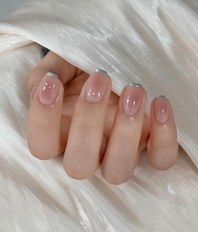 Nude nails with silver French metallic tips.