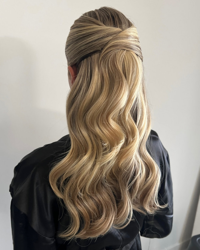 Sleek half-up bridal hairstyle with twisted crown and soft blonde waves by @erikataftbridal. Half-up romantic bridal hairstyle with floral crown