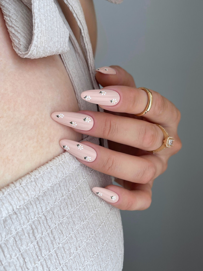 Minimalist floral nail idea with nude base and daisy accents