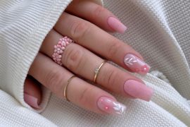 Elegant soft pink bridal nails with delicate white leaves and 3D pink flower accents, perfect for a romantic wedding look. Elegant bridal nail designs with nude tones