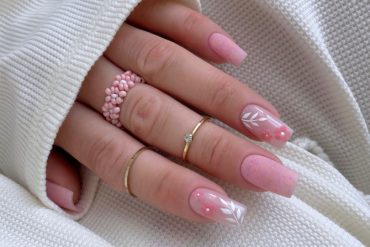 Elegant soft pink bridal nails with delicate white leaves and 3D pink flower accents, perfect for a romantic wedding look. Elegant bridal nail designs with nude tones