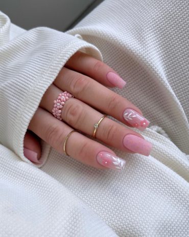 Elegant soft pink bridal nails with delicate white leaves and 3D pink flower accents, perfect for a romantic wedding look. Elegant bridal nail designs with nude tones