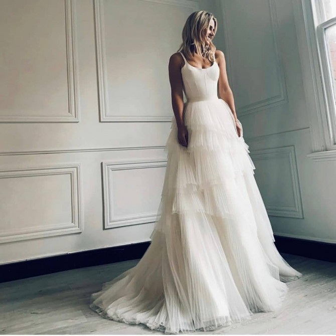 Bride in draped one-shoulder modern wedding gown