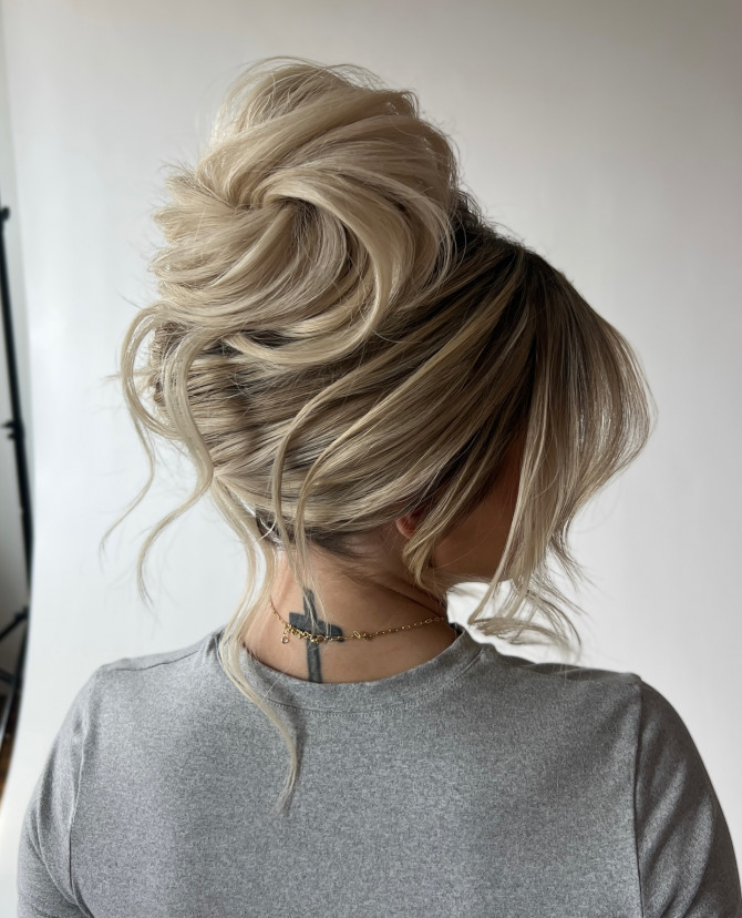 Voluminous bridal top knot with textured blonde layers and soft loose tendrils by @erikataftbridal