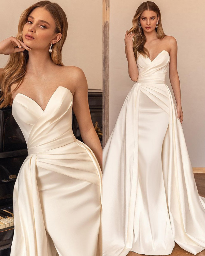 White floral lace bridal gown with long sleeves and flowing skirt. Timeless Bridal Gowns with lace details